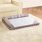 Graues modernes Haustierbett auf beigem Teppich neben beigem Sofa, ideal für Hunde und Katzen.