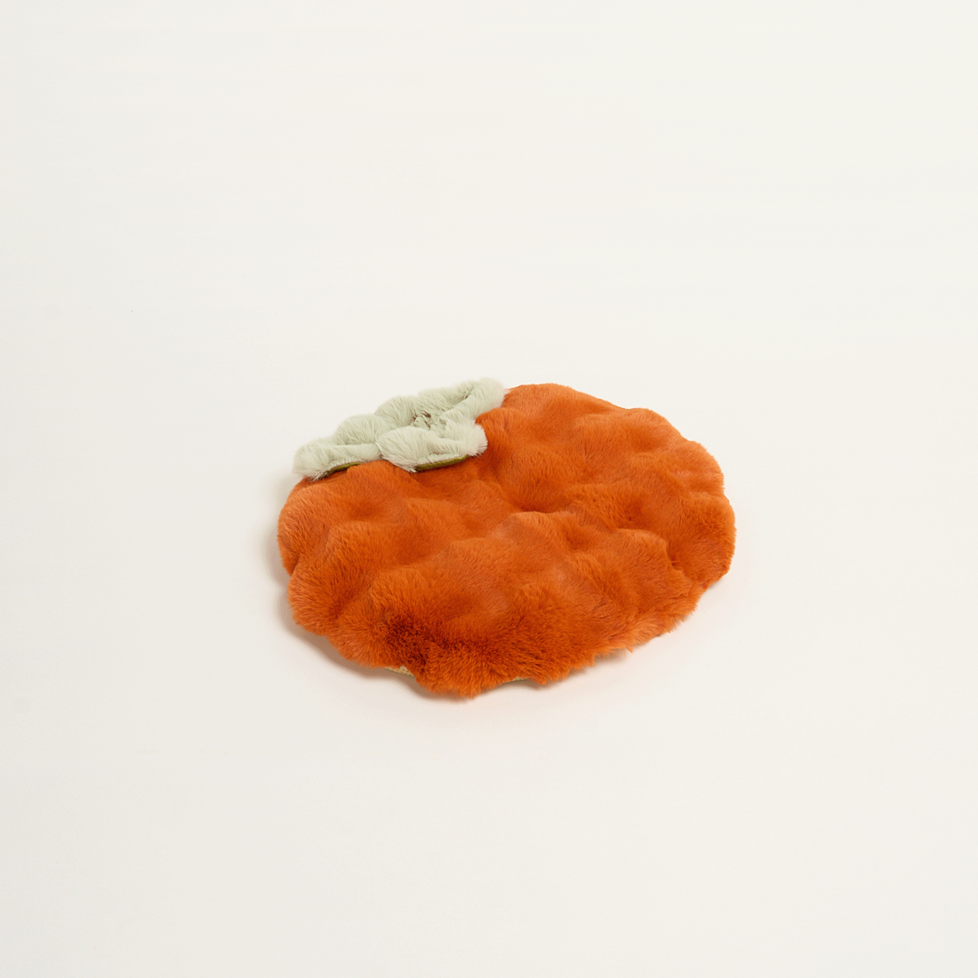 Orangefarbene, runde Schlafmatte aus Plüsch in Kürbisform, ideal für Haustiere.