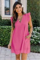 Frau in rosa Sommerkleid mit Spitzenmuster, lächelnd im Garten. Perfekt für Sommermode, Freizeitkleidung, Damenkleider, stilvolle Outfits.