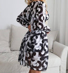 Schwarzes und weißes geometrisches Kleid mit langen Ärmeln, ideal für moderne Mode. Perfekt für stilvolle Anlässe und trendbewusste Frauen.
