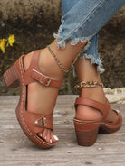 Damen Sandalen mit Blockabsatz, braunem Leder, verstellbarer Schnalle und Ketten-Detail. Perfekt für Sommermode und Freizeitoutfits.