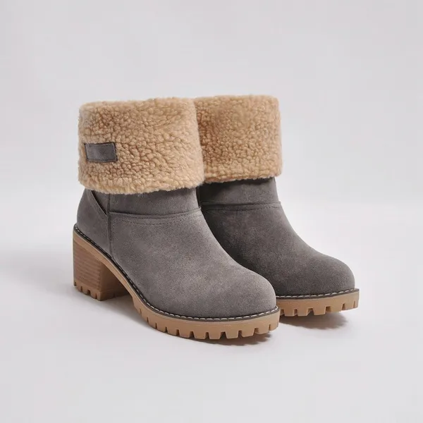 Graue Damenstiefeletten mit Absatz, gefüttert mit Kunstfell, rutschfeste Sohle, ideal für Wintermode. Elegante und warme Winterstiefel.