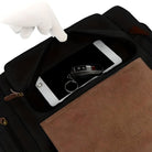 Schwarze Ledertasche mit brauner Klappe, enthält Tablet und Autoschlüssel, elegante Aufbewahrung.