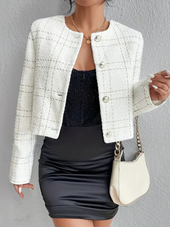 Elegante Damenmode: Weißer karierter Blazer, kombiniert mit schwarzem Rock und Tasche. Perfekt für stilvolle, moderne Outfits und Business-Looks.