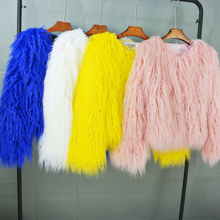 Bunte Kunstpelzjacken in Blau, Weiß, Gelb und Rosa auf Kleiderbügeln. Modetrend, stilvolle Damenbekleidung, auffällige Farben.
