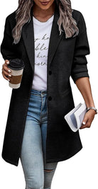 Frau in schwarzem Blazer, weißem T-Shirt, Jeans, hält Kaffeebecher und Zeitschrift.