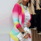 Farbintensiver Damenblazer in Regenbogenoptik, kombiniert mit weißer Spitzenbluse und stilvoller Handtasche. Perfekt für modische Outfits.