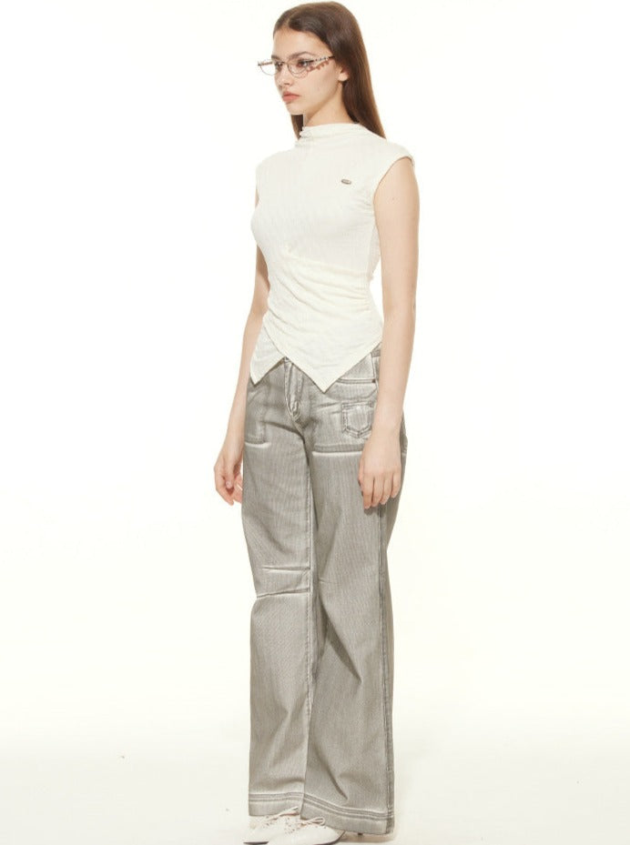 Frau in modischer, ärmelloser, weißer Bluse und grauer, weiter Jeanshose. Trendige Damenmode, lässiger Look, stilvolle Kleidung.