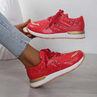Rote Damen-Sneaker mit goldenen Akzenten, gepolstertem Design und weißer Sohle. Modische Sportschuhe, ideal für Freizeit und Sport.