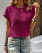 Damen T-Shirt in kräftigem Pink, geripptes Design, kombiniert mit lässigen Jeans. Perfekt für Sommermode und Freizeitoutfits.