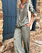 Elegantes Damen-Outfit in Olivgrün mit weiten Hosen und auffälligen Halsketten, ideal für modische Freizeitlooks. Boho-Chic, Damenmode, Sommertrends.