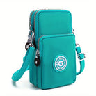 Türkise Umhängetasche mit zwei Reißverschlussfächern, verstellbarem Schultergurt und stylischem Logo-Patch. Perfekt für Damenmode und Accessoires.