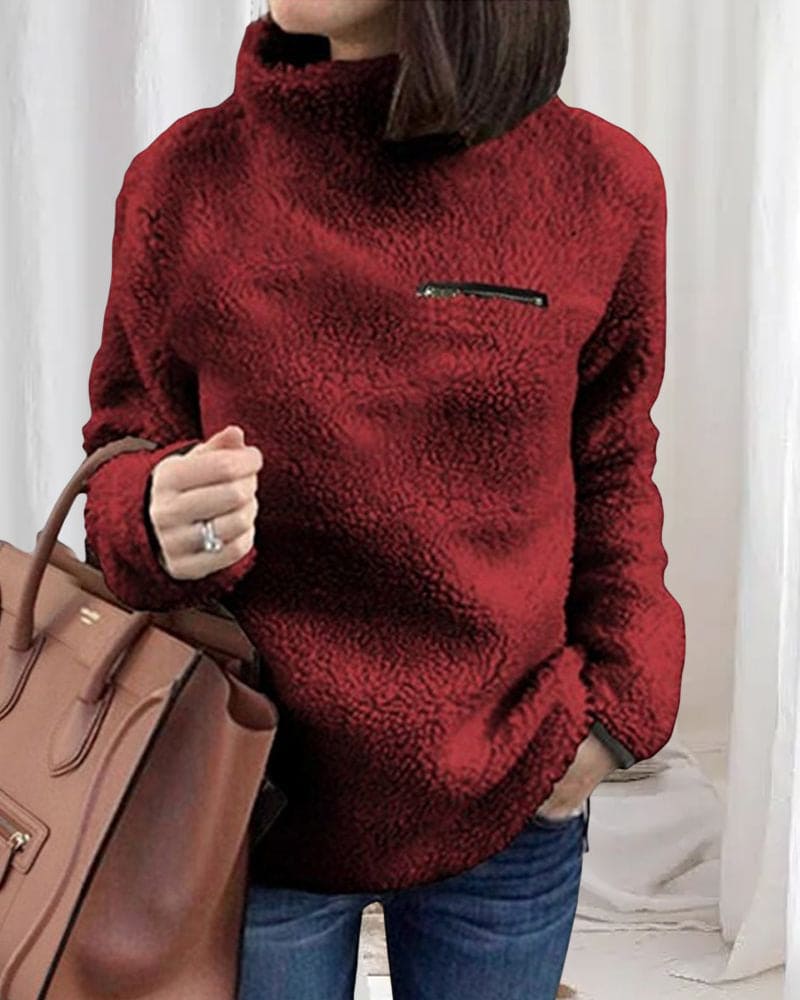 Roter Teddy-Fleece-Pullover mit hohem Kragen und Reißverschlusstasche, kombiniert mit brauner Handtasche. Perfekt für Herbstmode und Damenbekleidung.