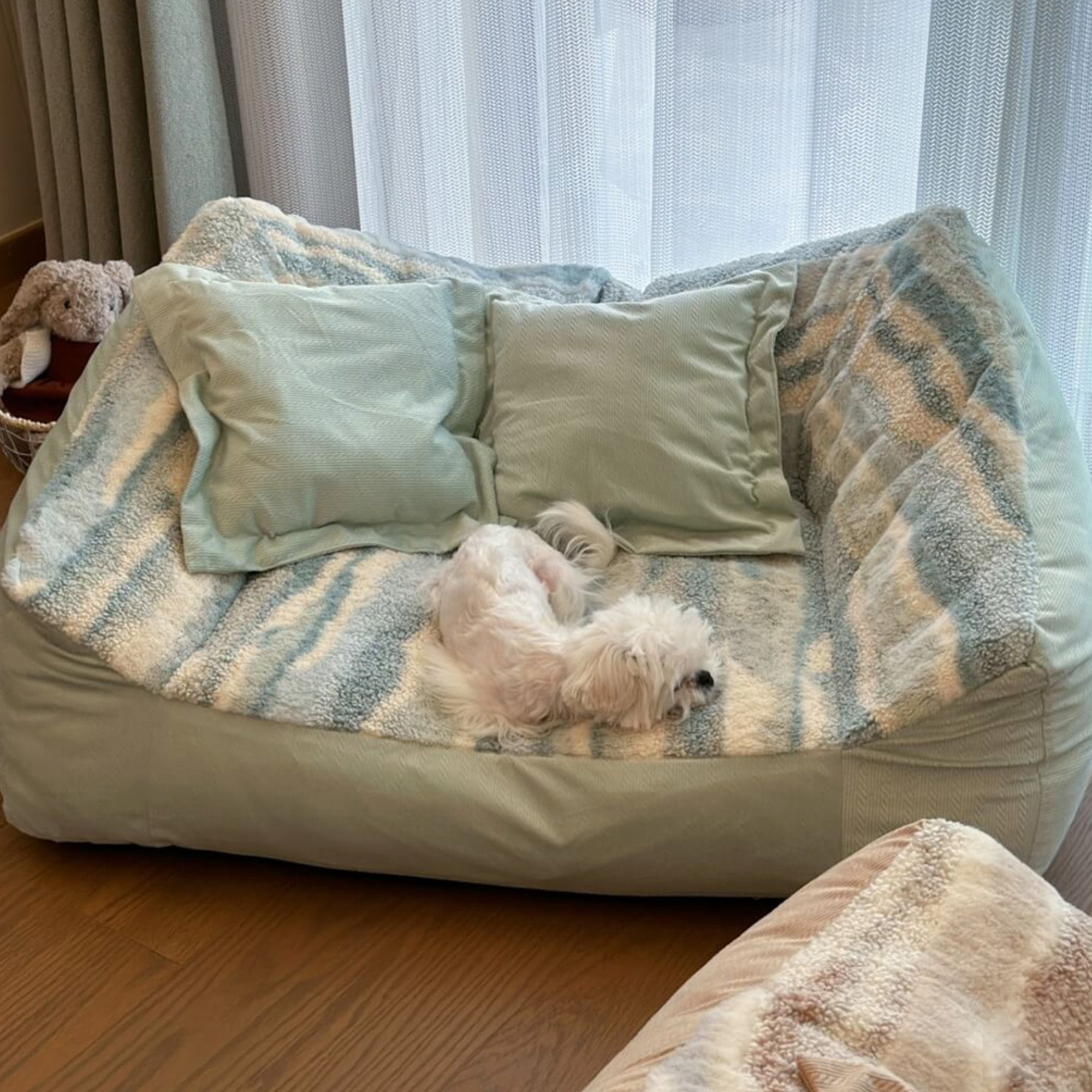 Hundesofa aus Polarfleece in Pastellfarben mit kleinem Hund, gemütlich und stilvoll.