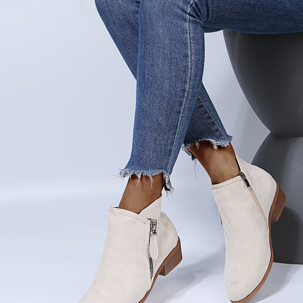Damenstiefeletten aus Wildleder in Beige mit Reißverschluss, kombiniert mit modischen, ausgefransten blauen Jeans. Perfekt für Herbstmode.
