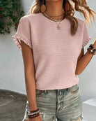 Damenmode: Rosa Rüschen-T-Shirt, lässig, kombiniert mit Jeansshorts. Perfekt für Sommeroutfits. Trendige Freizeitkleidung für Frauen.