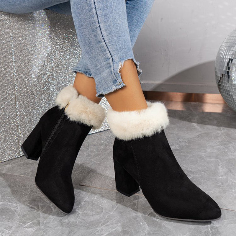 Damenstiefeletten mit schwarzem Wildleder und weißem Kunstfellbesatz, kombiniert mit hellblauen Jeans. Modische Winterstiefel für Damen.