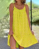 Gelbes Sommerkleid mit Blumenmuster, ärmellos und luftig, ideal für Strandmode. Perfekt für warme Tage und lässige Outfits.