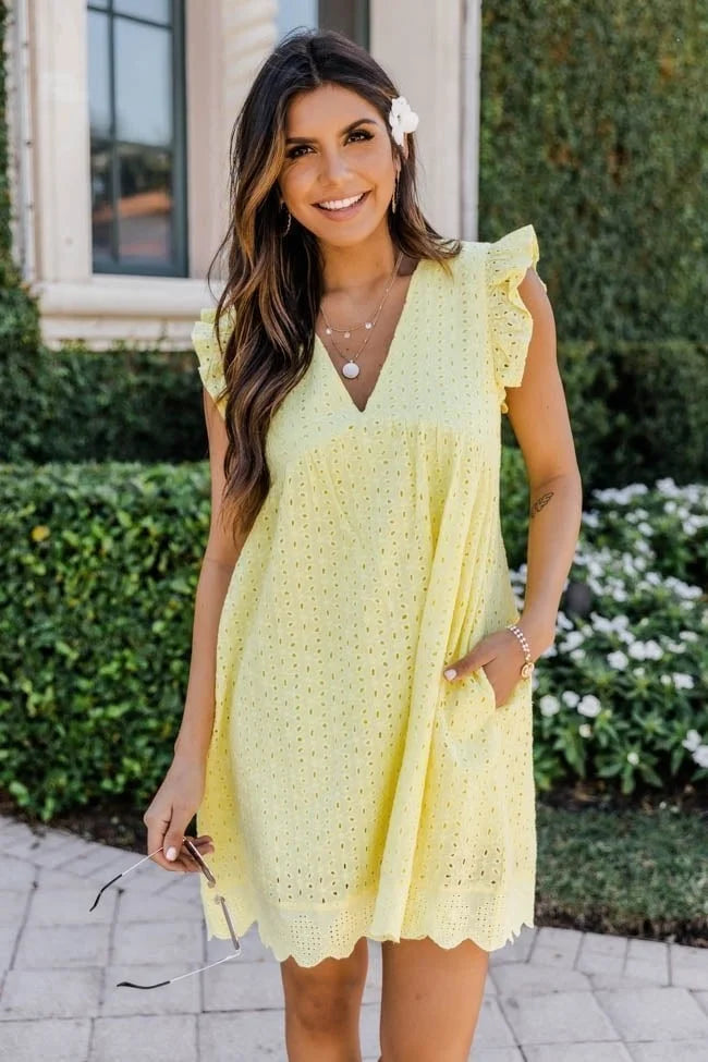 Frau in gelbem Sommerkleid mit Spitzenmuster, lächelnd im Garten. Perfekt für Sommermode, Freizeitkleidung, Damenkleider, stilvolle Outfits.