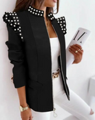Elegante schwarze Jacke mit Perlenverzierung, Reißverschluss und Schulterdetails, kombiniert mit weißem Top und Hose. Perfekt für modische Outfits.