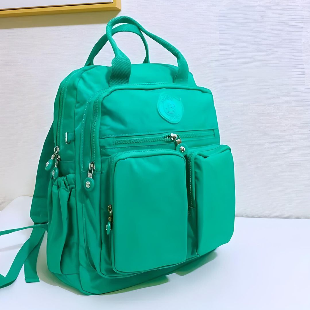 Grüner Rucksack mit mehreren Taschen, Reißverschlüssen, ideal für Schule oder Reisen.