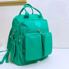 Grüner Rucksack mit mehreren Taschen, Reißverschlüssen, ideal für Schule oder Reisen.
