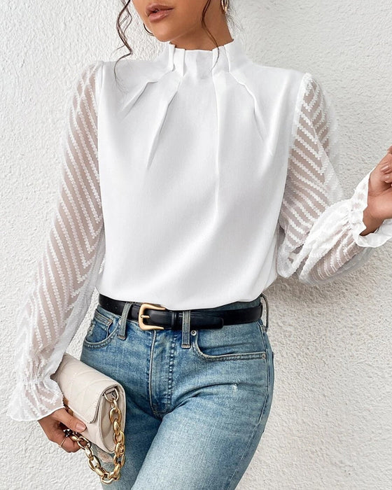 Elegante weiße Bluse mit transparenten Ärmeln und Chevron-Muster, kombiniert mit blauer Jeans. Perfekt für stilvolle Damenmode und Freizeitoutfits.