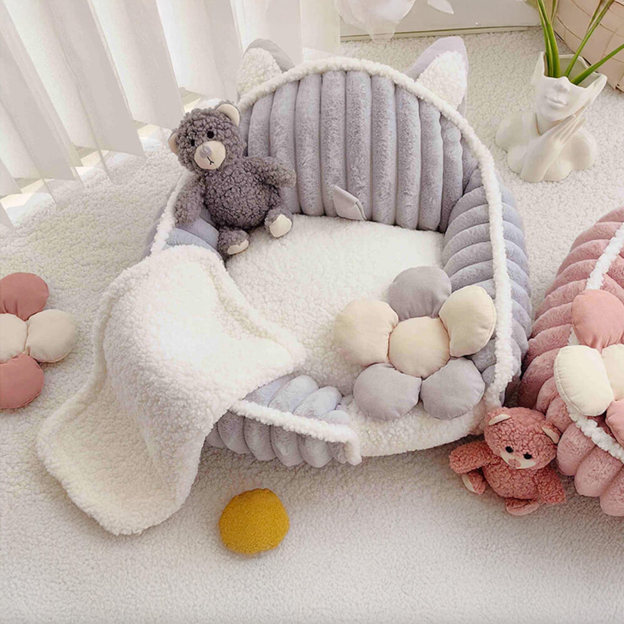Waschbares, flauschiges Hundebett in Creme und Rosa mit Plüschblumen und Kuscheltier.