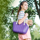 Frau mit lila EVA-Haustiertasche, wasserdicht, große Kapazität, Outdoor-Nutzung.