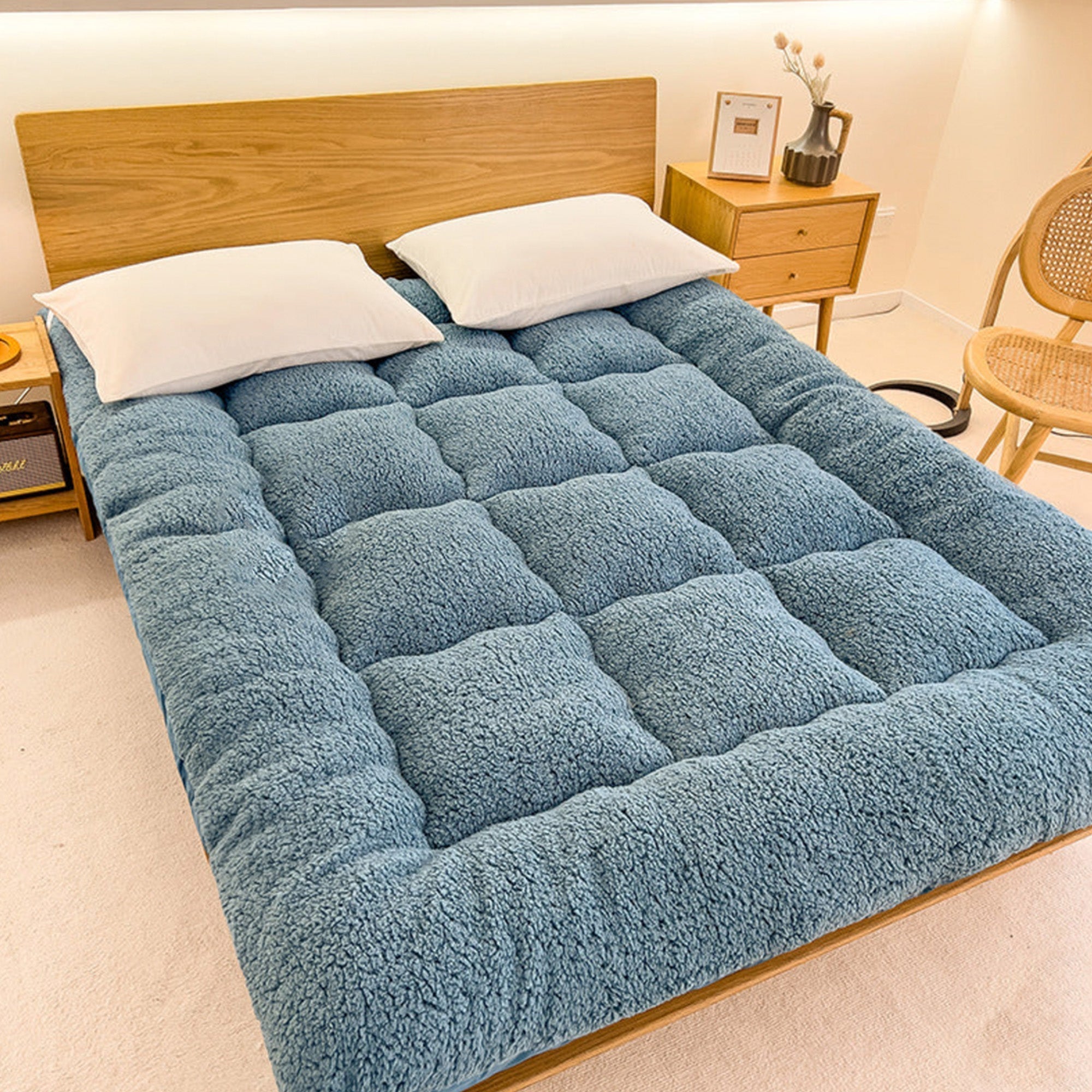 Große blaue Lammwoll-Matratzenauflage auf Holzbett, gemütlich und weich, Schlafzimmerdekor.