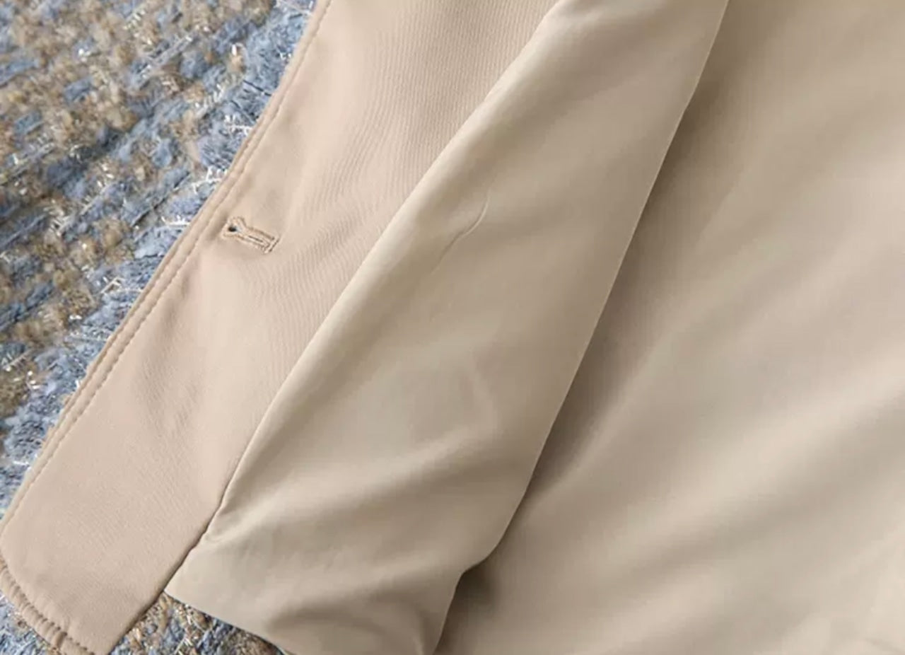 Beige Mantel auf strukturiertem Stoff, elegantes Design, hochwertige Verarbeitung, ideal für stilvolle Herbst- und Wintermode.