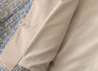 Beige Mantel auf strukturiertem Stoff, elegantes Design, hochwertige Verarbeitung, ideal für stilvolle Herbst- und Wintermode.