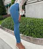 Damen-Jeans im 90er-Jahre-Stil, Skinny-Fit, aus Denim. Perfekt für trendige Outfits. Kombiniert mit weißer Spitzenbluse und High Heels.