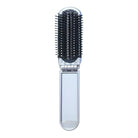 Silberne faltbare Haarbürste mit schwarzen Borsten, ideal für unterwegs, kompakt und praktisch.