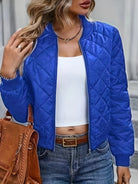 Blaue Steppjacke Damenmode, kombiniert mit weißem Top und Jeans. Trendige Herbstbekleidung, ideal für stilvolle Freizeitoutfits.