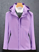 Lila Damenjacke mit Kapuze, wasserdicht und winddicht, ideal für Outdoor-Aktivitäten. Modisches Design, funktional und vielseitig einsetzbar.