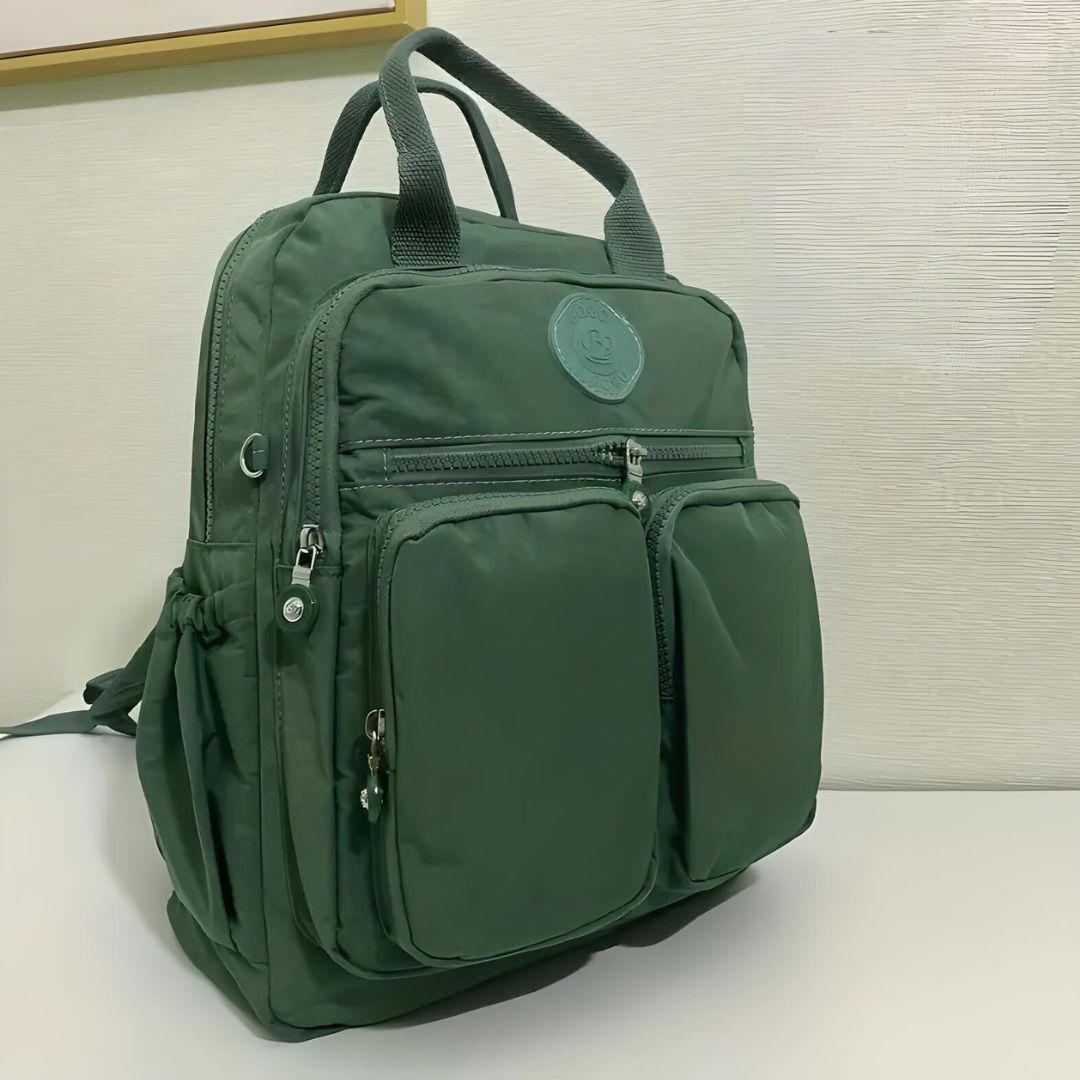 Grüner Rucksack mit mehreren Taschen, Reißverschlüssen, ideal für Reisen und Alltag.