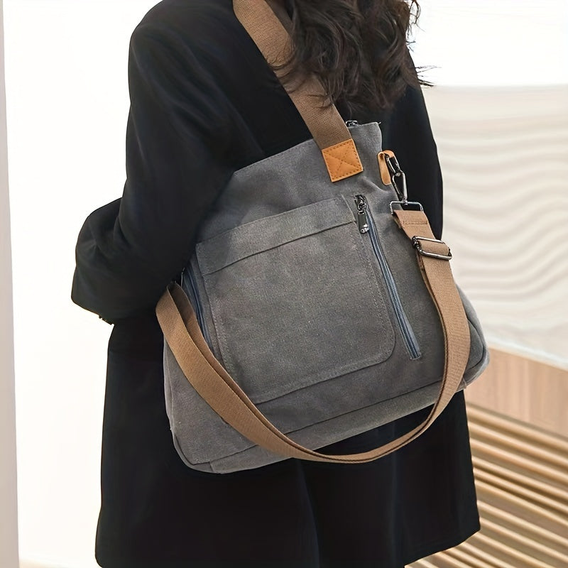 Damen-Umhängetasche aus grauem Canvas mit verstellbarem Riemen und Reißverschlusstasche, ideal für Alltag und Reisen, modisch und praktisch.