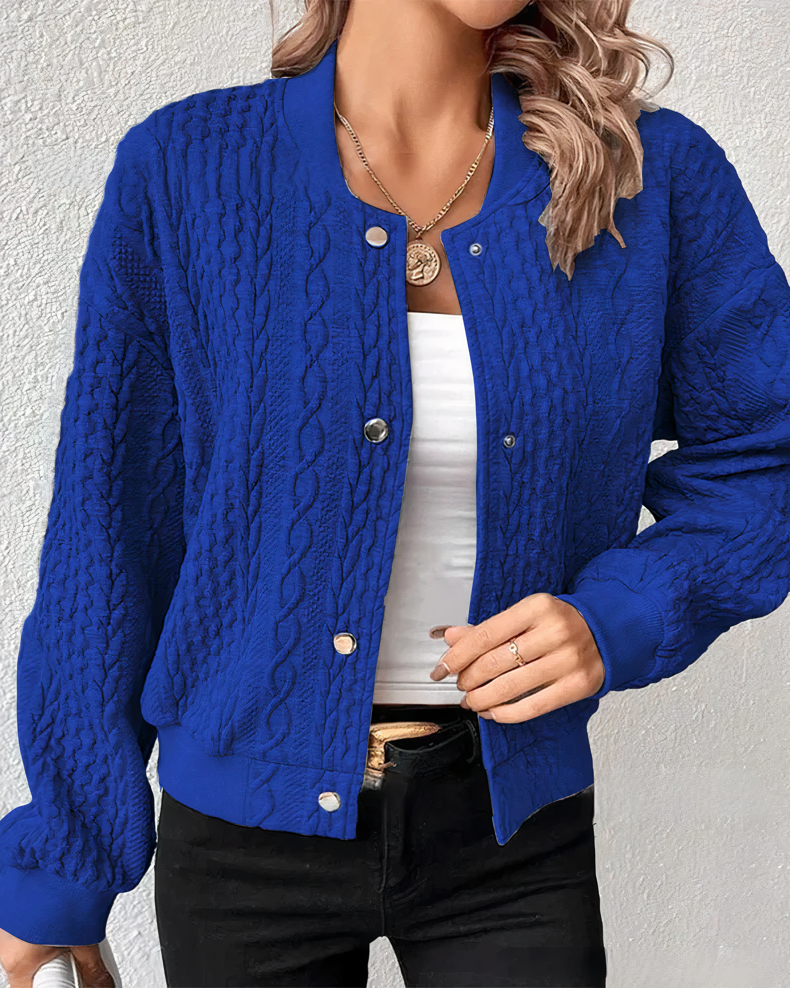 Damen Strickjacke in leuchtendem Blau, Zopfmuster, lässiger Stil. Perfekt für Herbstmode, kombiniert mit weißem Top und schwarzer Hose.