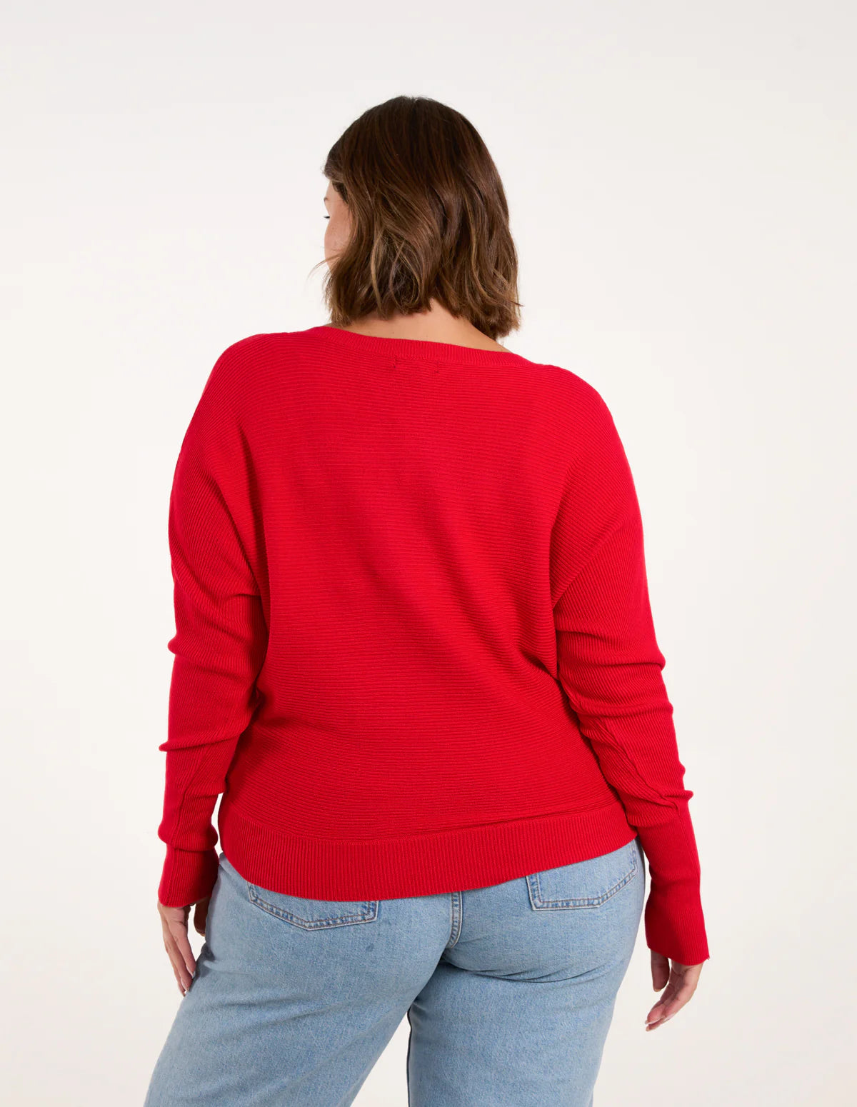Roter Damenpullover aus Strick, langärmlig, lässiger Schnitt. Perfekt für Herbstmode, kombiniert mit blauen Jeans. Bequem und stilvoll.