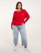 Roter Pullover Damen, V-Ausschnitt, lässig, weiches Material, kombiniert mit hellblauen Jeans, modisch, bequem, ideal für Herbstmode.