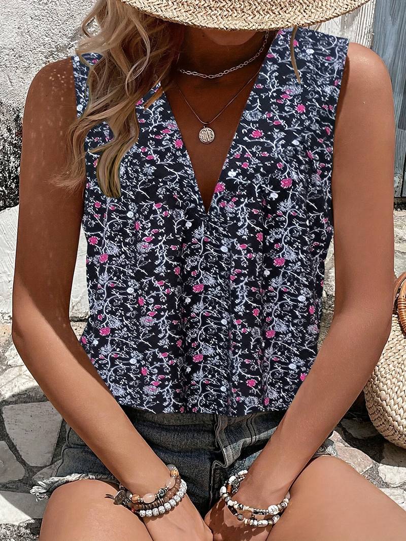 Damen-Sommeroutfit: Florales ärmelloses Top mit V-Ausschnitt, kombiniert mit Jeansshorts und Strohhut. Perfekt für lässige Sommermode.