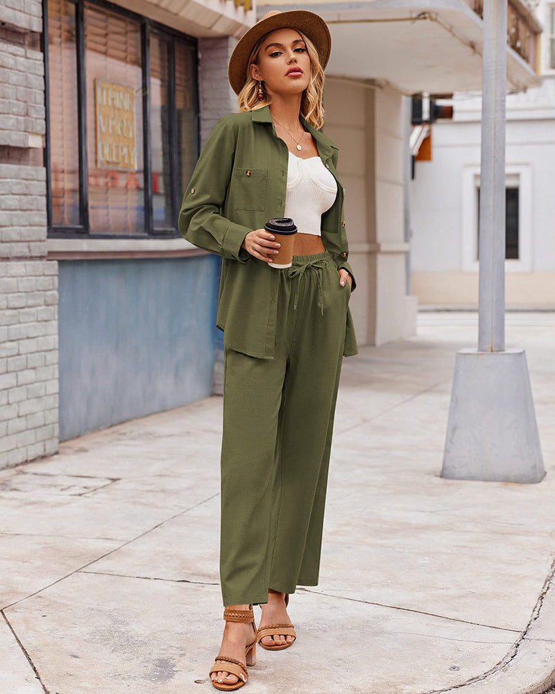 Frau in olivgrünem Freizeitanzug, kombiniert mit weißem Top und Strohhut, hält Kaffeebecher. Modetrend, urbaner Stil, lässige Eleganz.