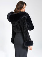 Eleganter schwarzer Kunstpelzmantel mit Kapuze, ideal für Wintermode. Luxuriöses Design, warm und stilvoll. Perfekt für Damenbekleidung.