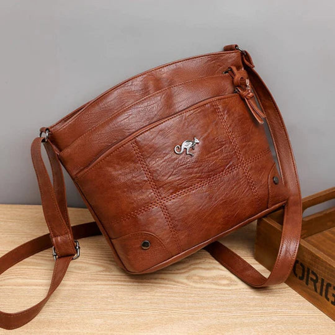 Damenhandtasche aus braunem Leder mit verstellbarem Schulterriemen, elegantem Design und silbernem Logo. Perfekt für stilvolle Alltagslooks.