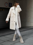 Damen Wintermantel in Cremeweiß, stilvoll und warm, mit doppelreihigem Design und Kunstfellbesatz. Perfekt für modische Winteroutfits.