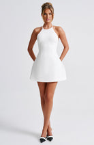 Weißes Minikleid mit Neckholder-Design, figurbetont und elegant. Perfekt für Partys oder besondere Anlässe. Damenmode, stilvoll, modern.