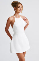 Weißes, ärmelloses Minikleid mit Neckholder, elegantes Design, ideal für Sommermode und Partys. Perfekt für stilvolle Anlässe.
