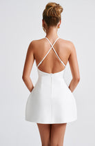 Weißes Minikleid mit überkreuzten Trägern, elegantes Design, ideal für Sommermode, Damenbekleidung, stilvoller Look, Rückenansicht.