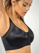 Frau in schwarzem Sport-BH, nahtlos, atmungsaktiv, ideal für Fitness und Alltag.